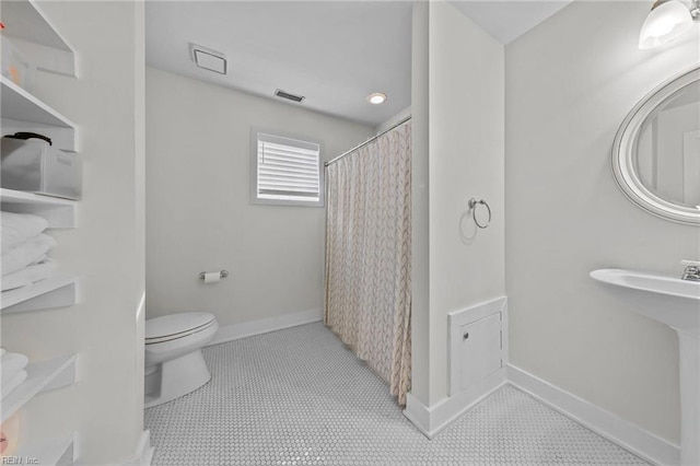 bathroom featuring curtained shower and toilet