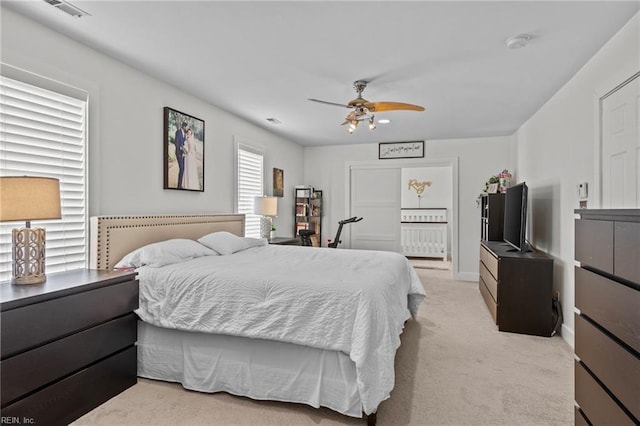 bedroom featuring light carpet, connected bathroom, radiator, and ceiling fan