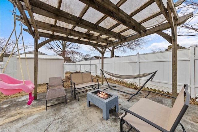 view of patio / terrace with a playground, a pergola, a shed, and an outdoor fire pit