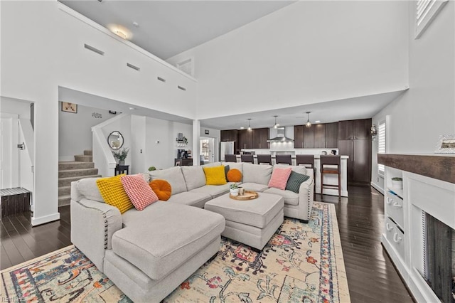 living room with a high ceiling and dark hardwood / wood-style floors