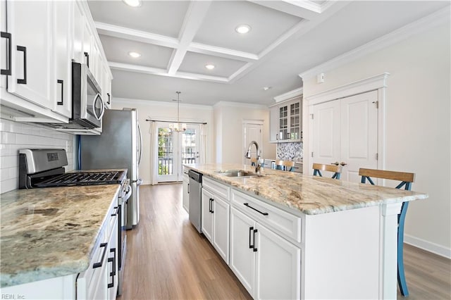 kitchen with sink, a center island with sink, a breakfast bar area, and appliances with stainless steel finishes