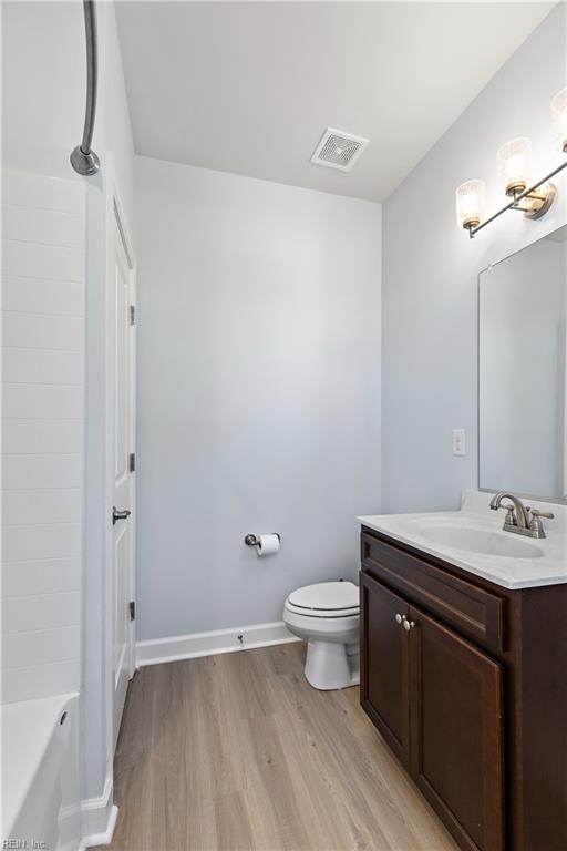 bathroom with hardwood / wood-style flooring, vanity, and toilet