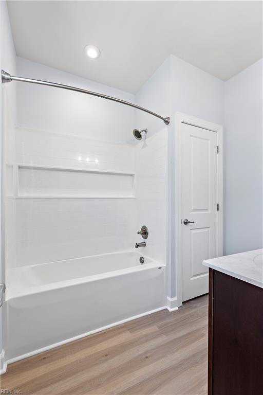 bathroom featuring vanity, shower / bath combination, and hardwood / wood-style floors