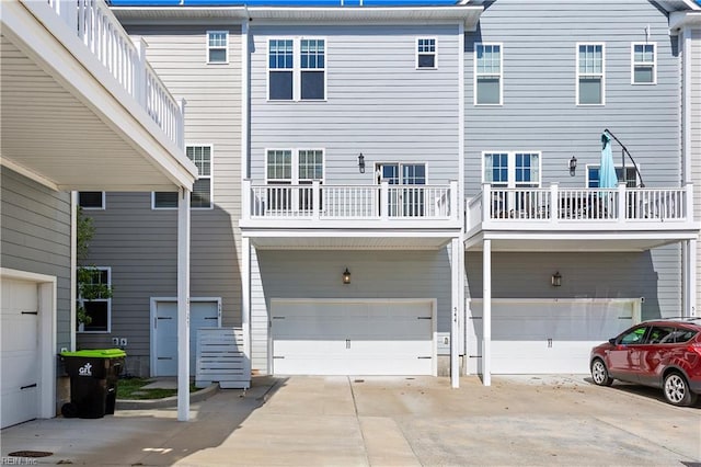 rear view of property with a balcony and a garage