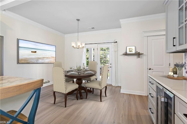 dining room featuring wine cooler, ornamental molding, a chandelier, and light wood-type flooring