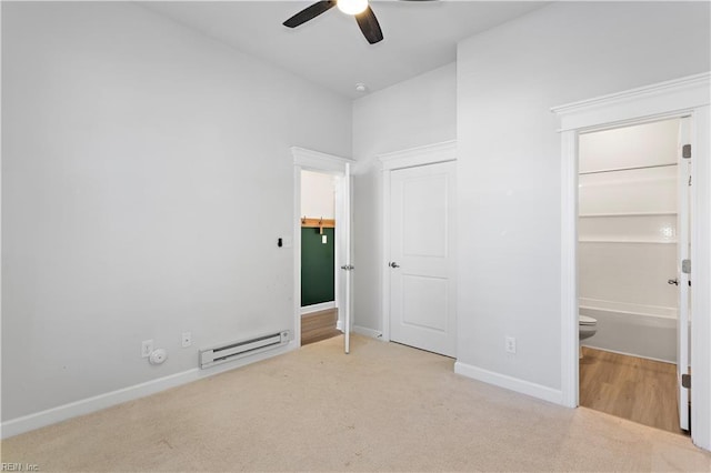 unfurnished bedroom featuring ceiling fan, connected bathroom, light colored carpet, and baseboard heating