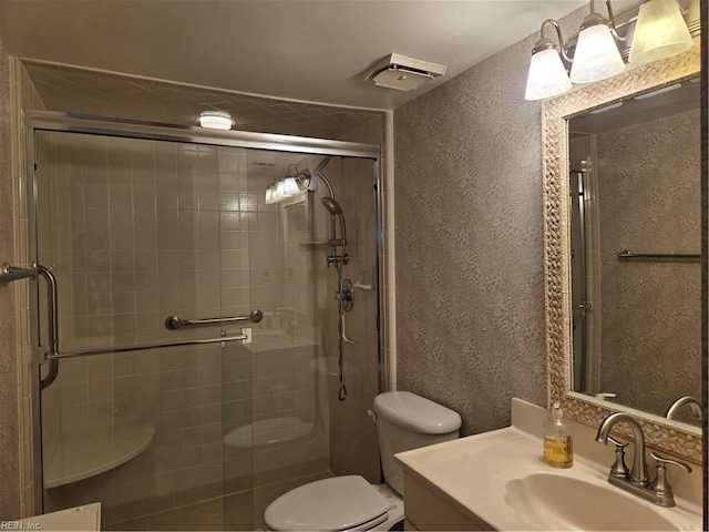 bathroom with an enclosed shower, vanity, and toilet