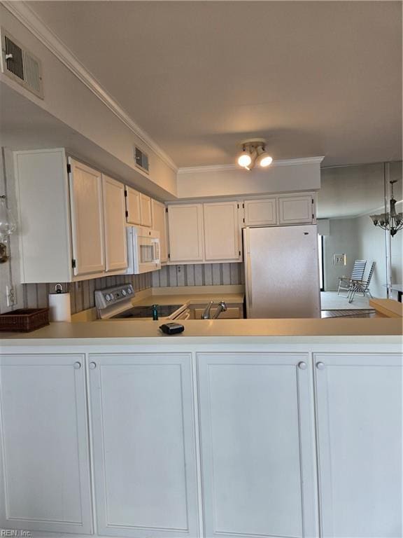 kitchen featuring sink, crown molding, refrigerator, range with electric cooktop, and white cabinets