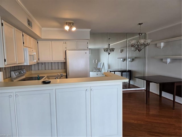 kitchen with white cabinetry, crown molding, kitchen peninsula, pendant lighting, and white appliances