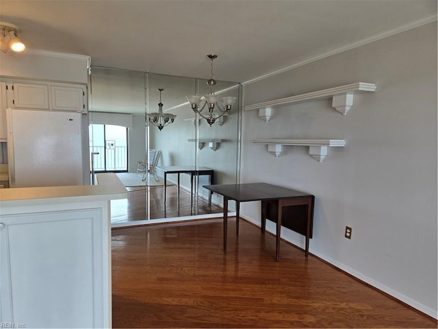 kitchen featuring white fridge, dark wood-type flooring, pendant lighting, and white cabinets