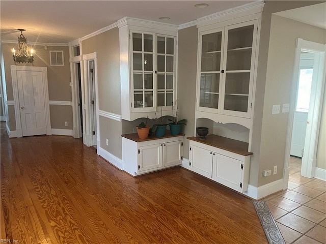 mudroom featuring hardwood / wood-style flooring, crown molding, and a notable chandelier