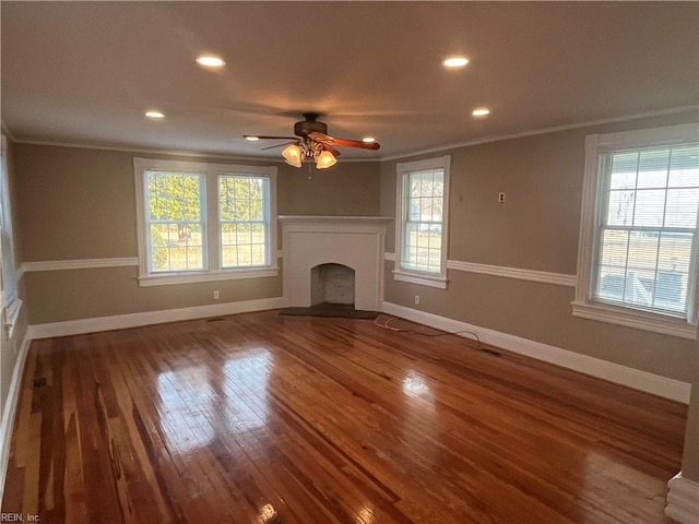 unfurnished living room with crown molding, plenty of natural light, and hardwood / wood-style floors