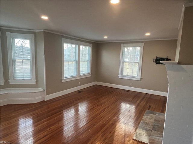 unfurnished room with crown molding, plenty of natural light, and dark hardwood / wood-style floors