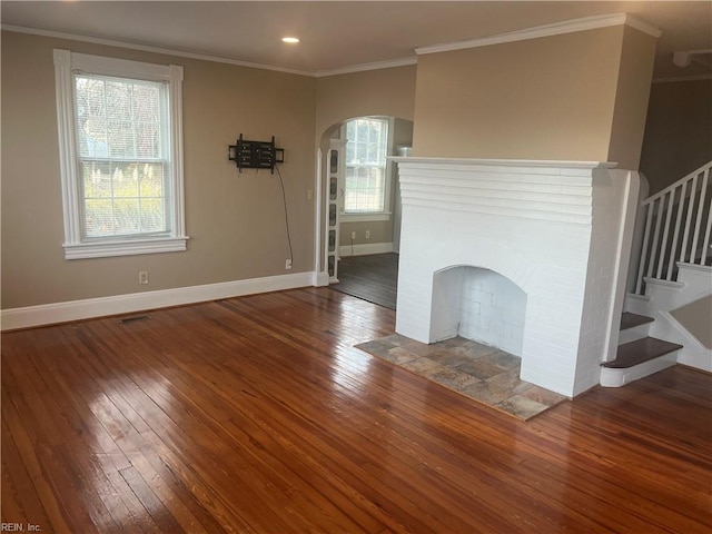 unfurnished living room featuring dark wood-type flooring, a fireplace, and crown molding