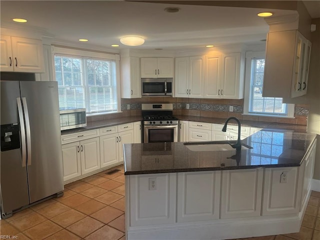 kitchen with white cabinetry, stainless steel appliances, kitchen peninsula, and sink