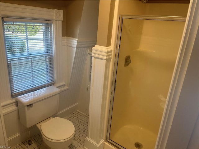 bathroom with tile patterned floors, a shower with door, and toilet