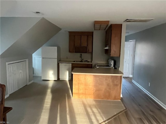 kitchen with lofted ceiling, sink, dishwasher, range, and white fridge