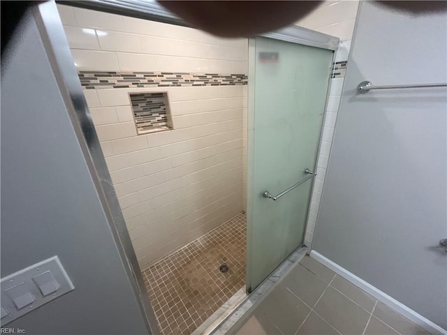 bathroom with tile patterned floors and a shower with door