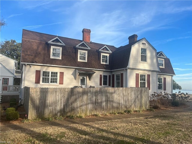 cape cod house featuring a front yard