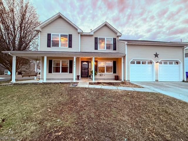 view of front of house with a garage, a front lawn, and covered porch