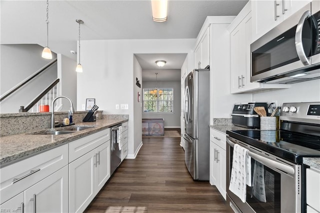 kitchen featuring stainless steel appliances, light stone countertops, sink, and white cabinets