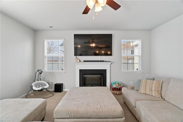 carpeted living room with ceiling fan