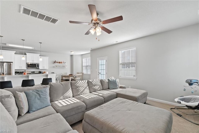 living room with light carpet and ceiling fan