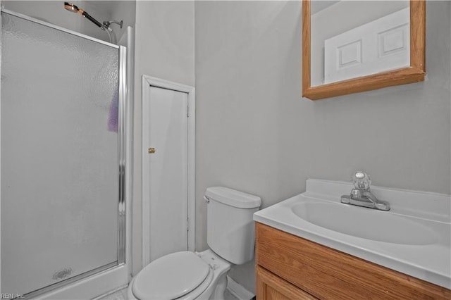 bathroom with a shower with door, vanity, and toilet