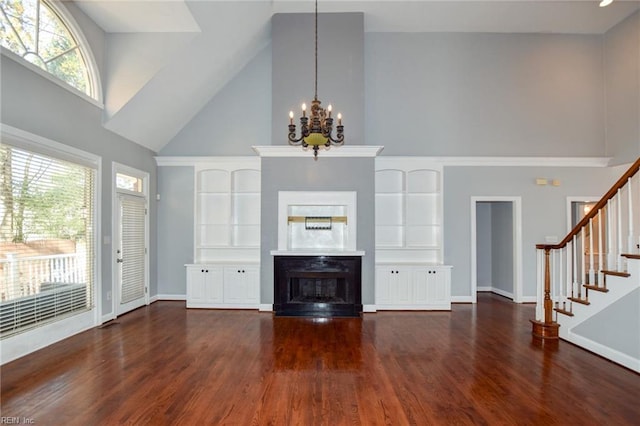 unfurnished living room with a high ceiling, a notable chandelier, and dark hardwood / wood-style flooring