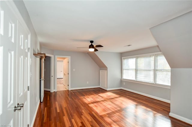 additional living space with dark hardwood / wood-style flooring, vaulted ceiling, and ceiling fan