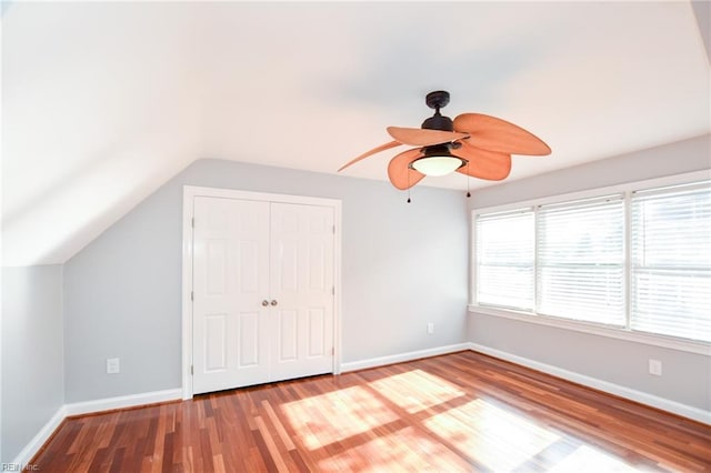 unfurnished bedroom with ceiling fan, wood-type flooring, vaulted ceiling, and a closet