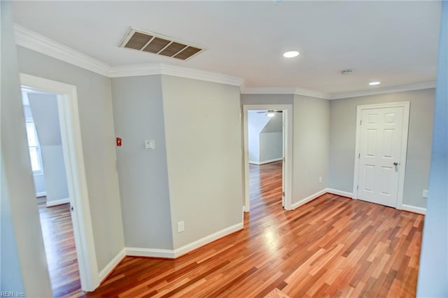 unfurnished room featuring ornamental molding and light wood-type flooring