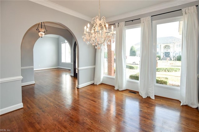 unfurnished dining area with dark hardwood / wood-style flooring, crown molding, and a chandelier