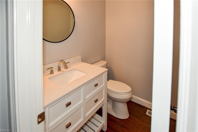 bathroom with vanity, hardwood / wood-style floors, and toilet