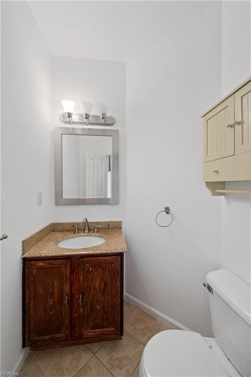 bathroom featuring tile patterned flooring, vanity, toilet, and baseboards