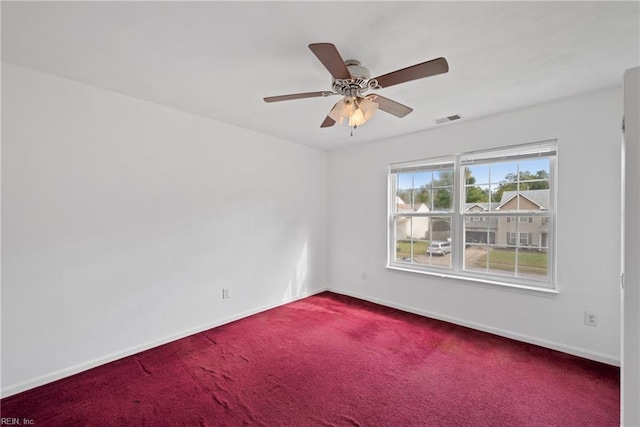 spare room featuring a ceiling fan, carpet, visible vents, and baseboards