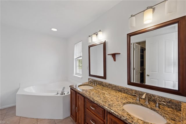 full bathroom with double vanity, tile patterned flooring, a sink, and a bath