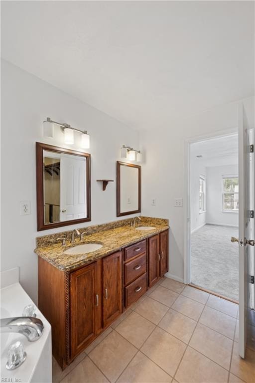 full bathroom featuring double vanity, a sink, and tile patterned floors