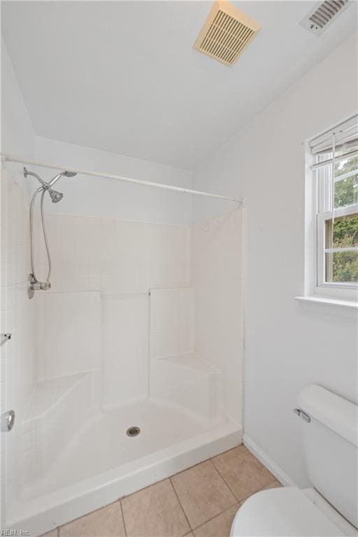 bathroom featuring a stall shower, visible vents, toilet, and tile patterned floors