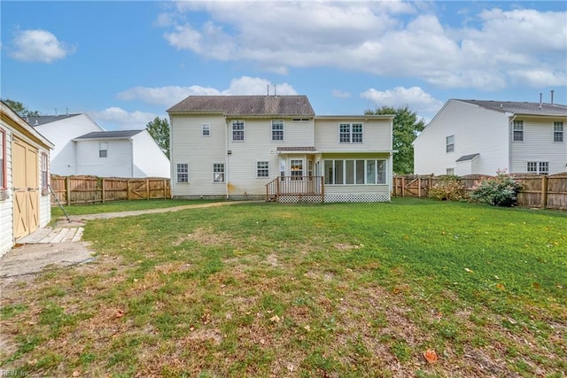 rear view of property featuring a fenced backyard and a lawn