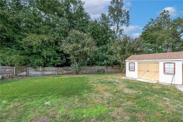 view of yard featuring an outbuilding, a fenced backyard, and a shed