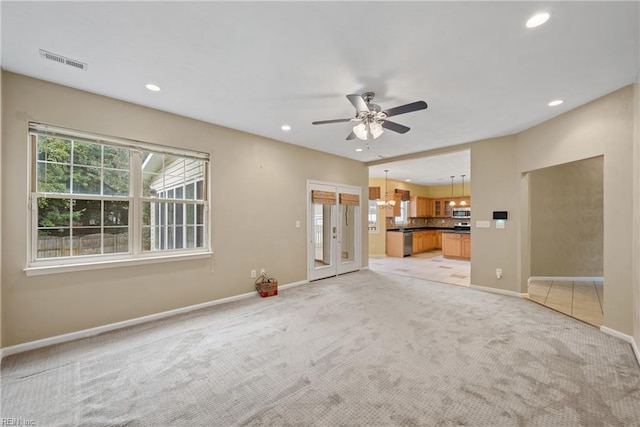 unfurnished living room with light carpet, a healthy amount of sunlight, visible vents, and recessed lighting