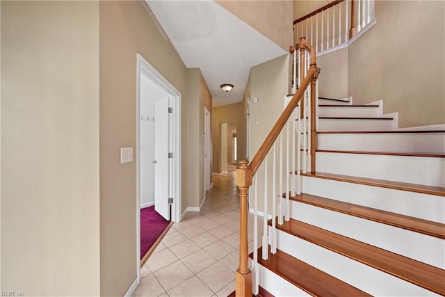 stairway featuring baseboards and tile patterned floors