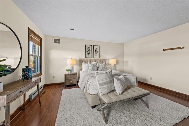 bedroom with dark hardwood / wood-style floors and a textured ceiling