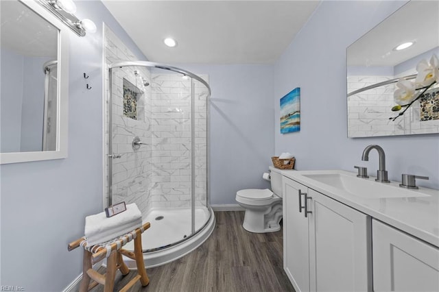 bathroom with walk in shower, vanity, toilet, and hardwood / wood-style floors