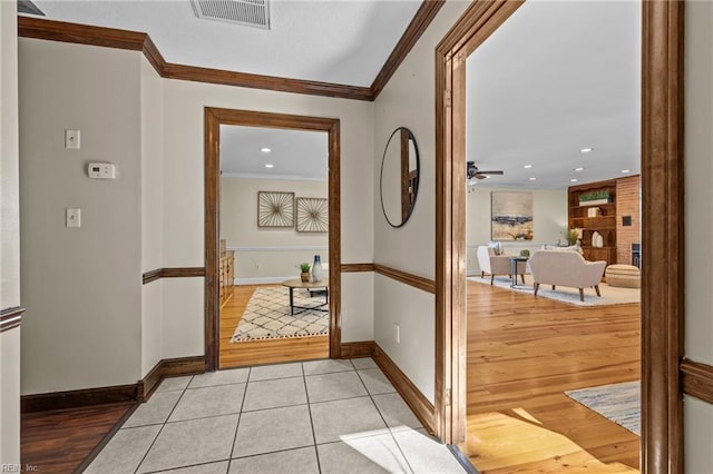 hallway with light tile patterned floors and ornamental molding