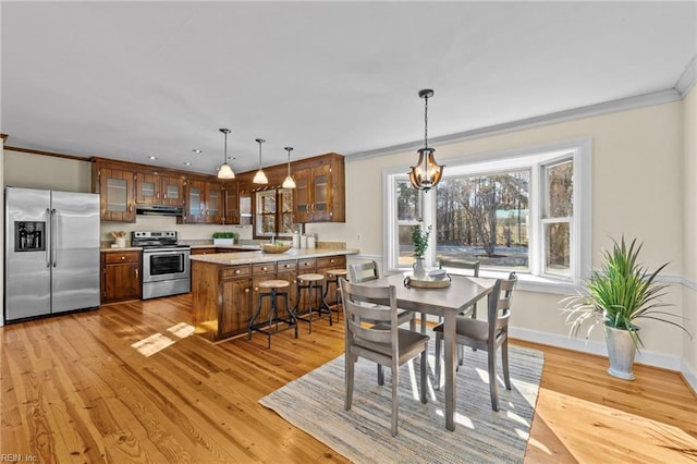 dining area featuring ornamental molding and light wood-type flooring