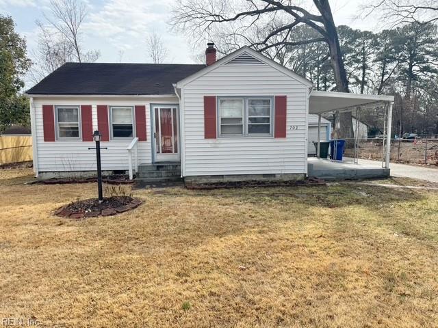 view of front of home with a front lawn and a carport