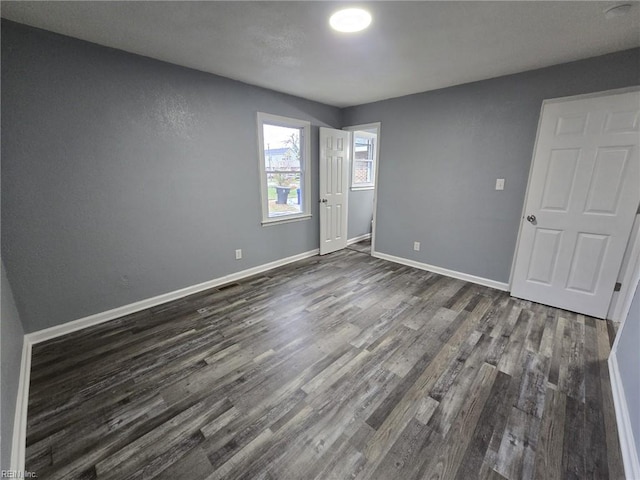 empty room with dark hardwood / wood-style flooring