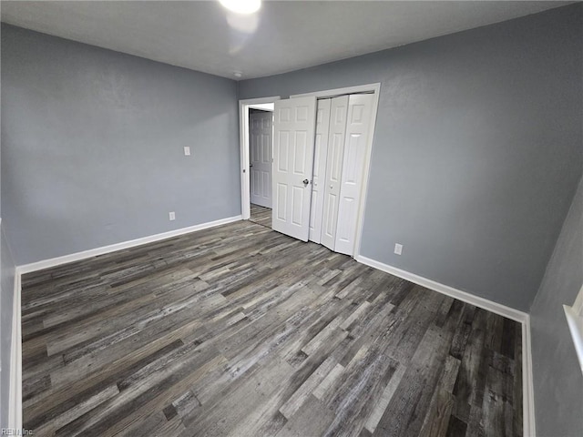 unfurnished bedroom with a closet and dark hardwood / wood-style floors